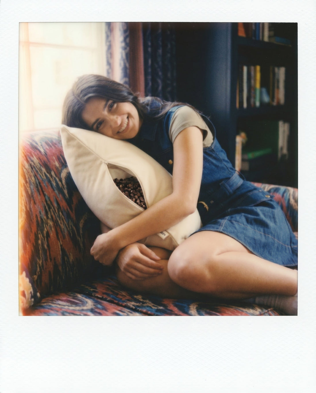 Woman in denim overalls hugging Circadian Buckwheat Pillow