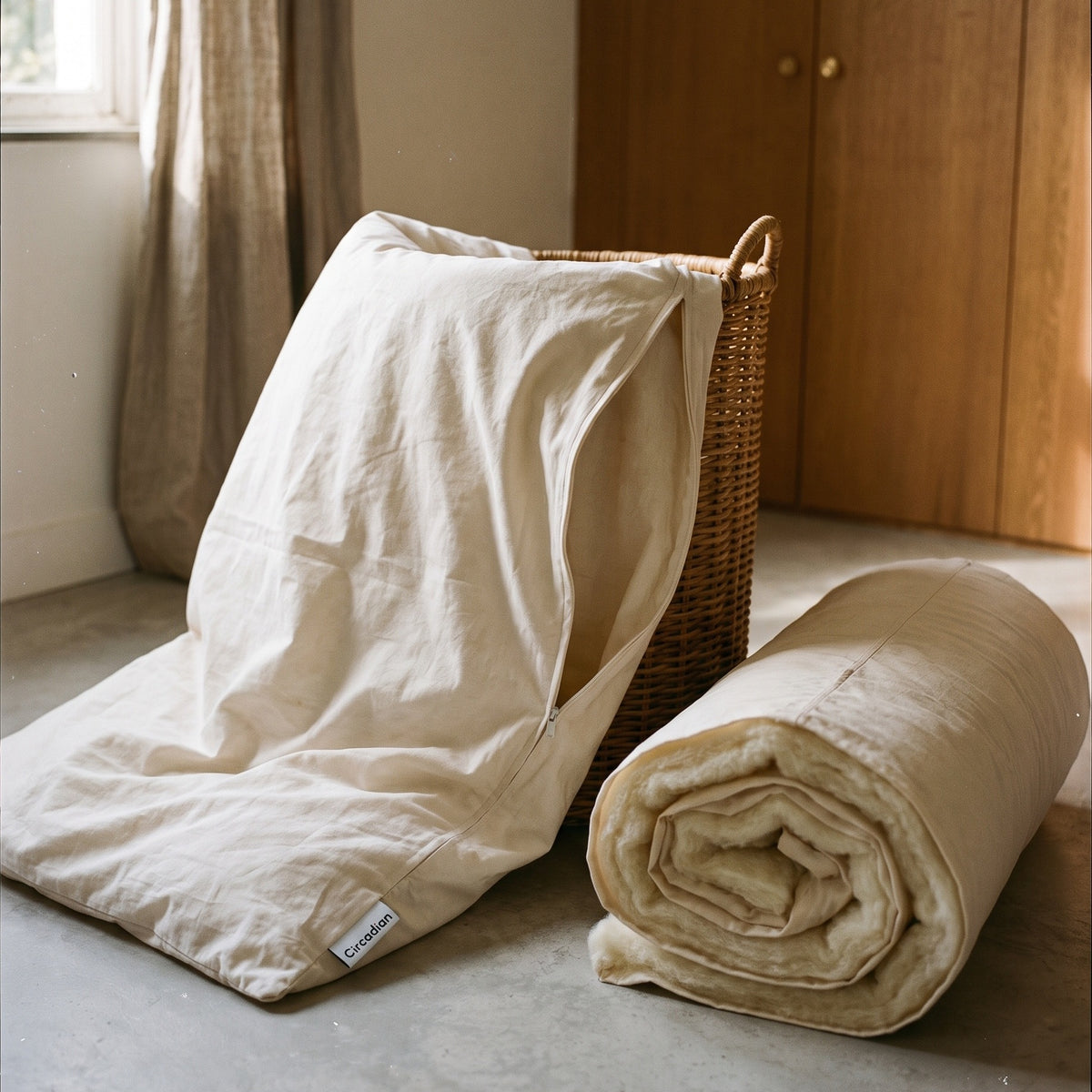 Circadian dog bed cover unzipped and pulled off into a laundry basket, with the wool-filled insert rolled beside it