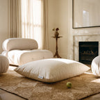Circadian dog bed filled with shredded tree-tapped latex, a flat cream cotton cushion on a rug in a sunlit sitting room