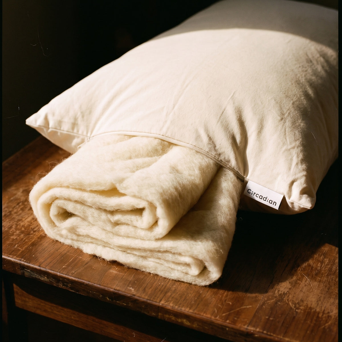 Sheets of washable merino wool batting drawn out through the open zipper of a Circadian dog bed