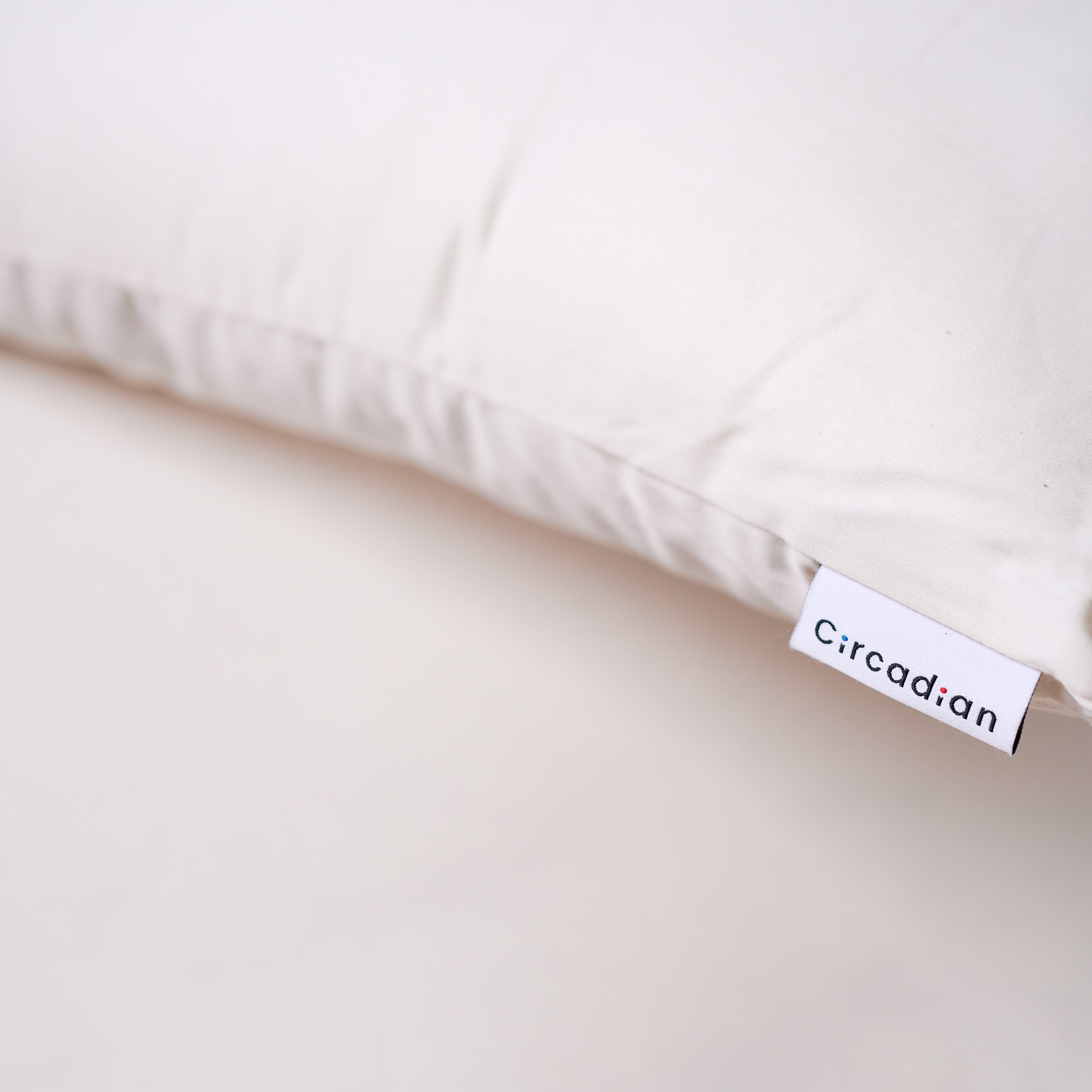 Woven Circadian brand tag sewn onto the organic cotton cover of a Circadian pillow, handmade in New Jersey.