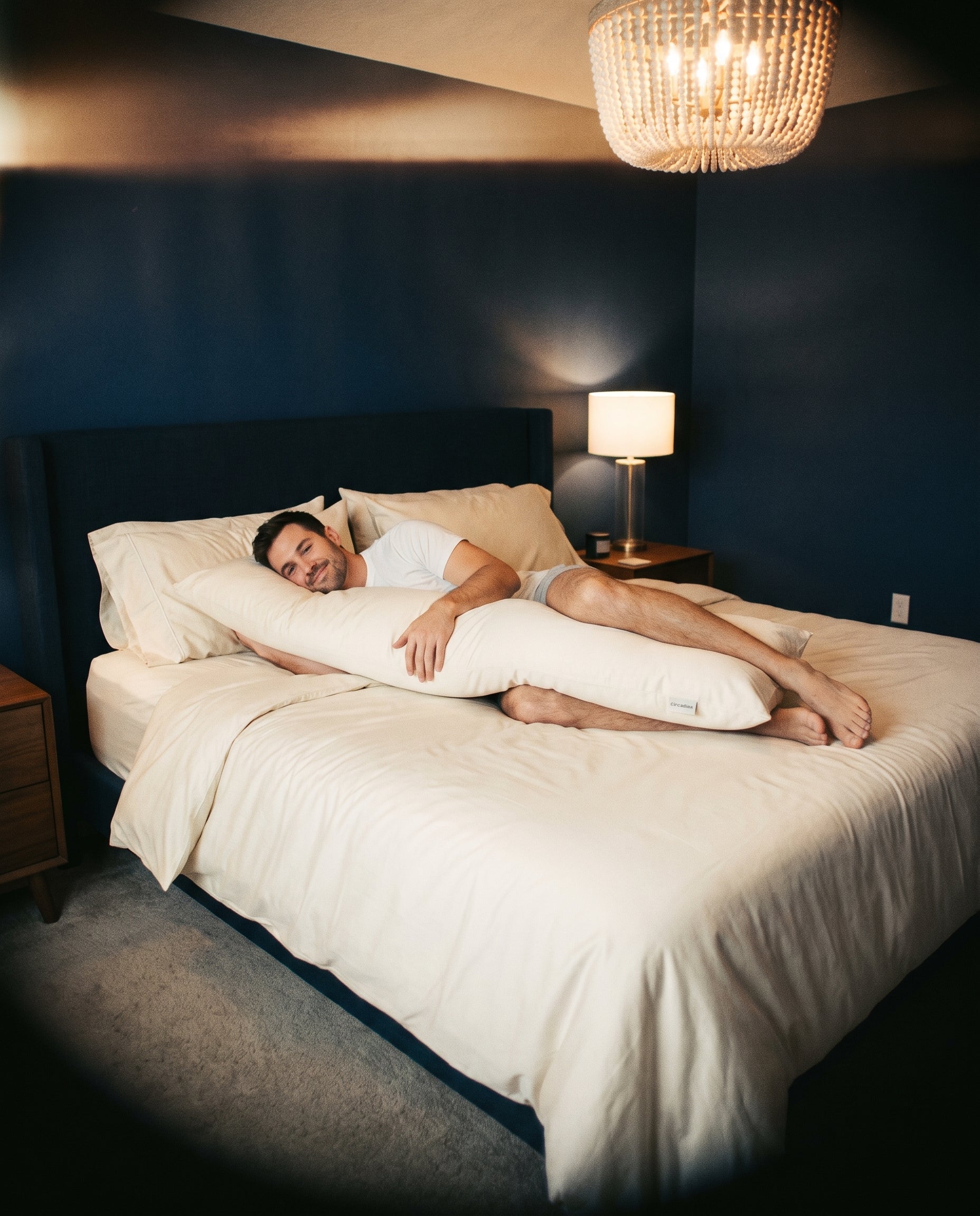 A man resting against a body pillow in an organic cotton case