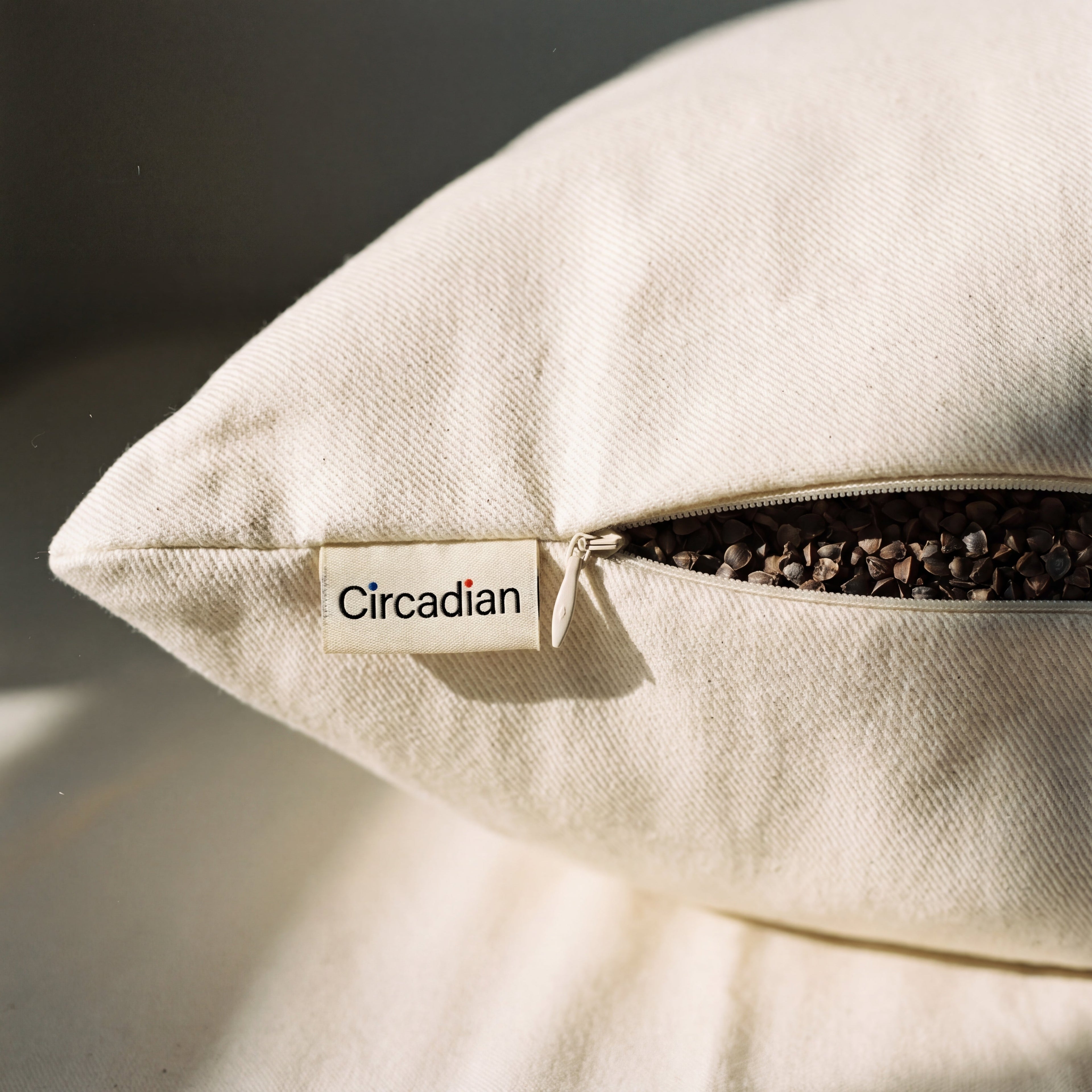 Concealed zipper and woven Circadian tag detail on the Buckwheat Pillow's organic cotton twill cover