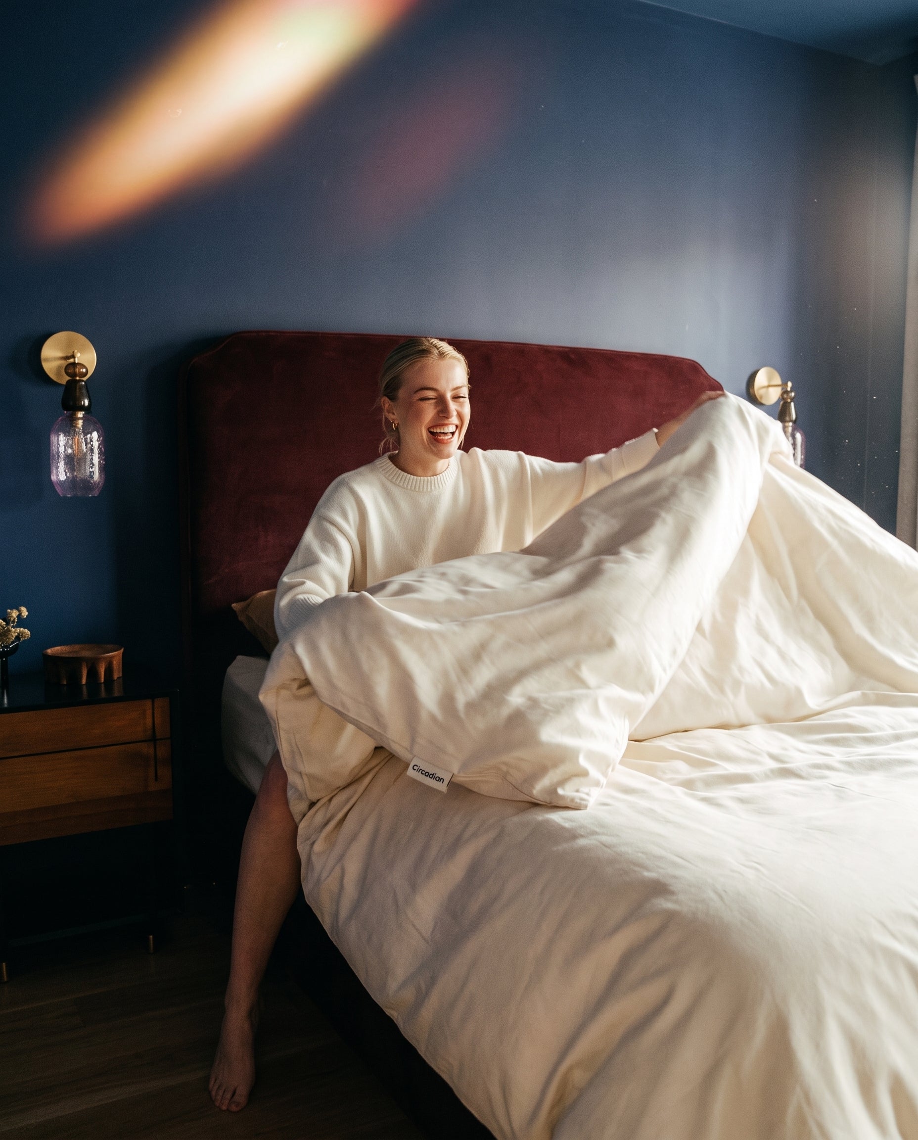 A woman shaking out an organic cotton duvet cover