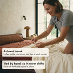 The cover is sold separately. Here a woman ties the corner loop of the comforter, a duvet insert, to the tie inside her own duvet cover.