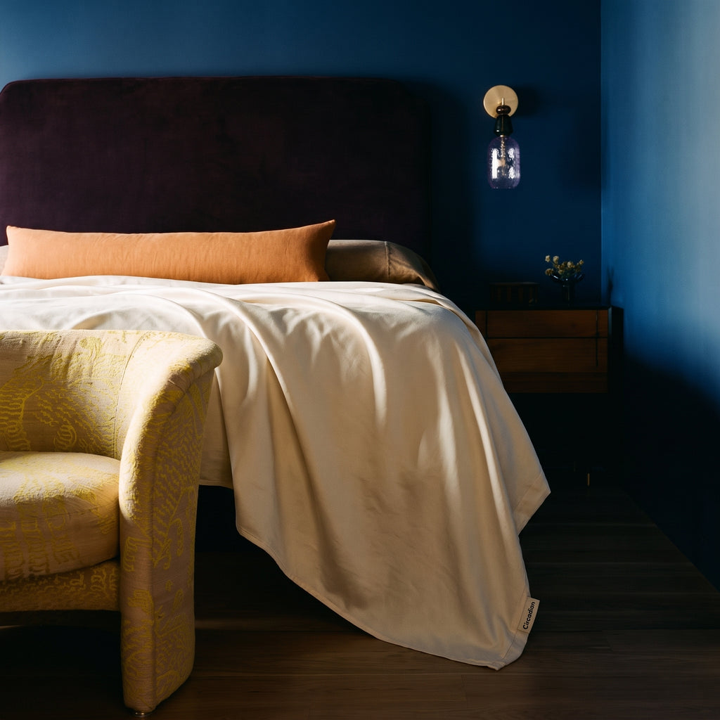An organic cotton flat sheet draped over the end of a bed