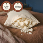 A Circadian Tree-Tapped Latex Pillow on a bed with its zipper open and soft, airy pieces of latex spilling out, with seals: rated Best by The Clean List, and handmade in the USA.
