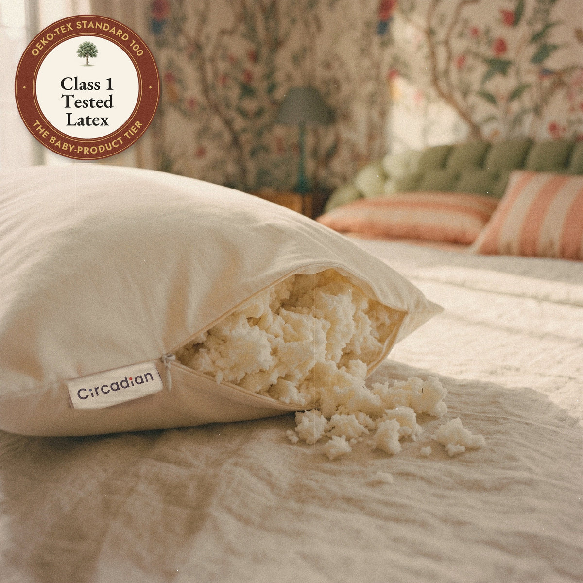The woven Circadian label beside the open zipper of the Tree-Tapped Latex Pillow, soft pieces of latex spilling onto the bed, with a seal: Class 1 tested latex.