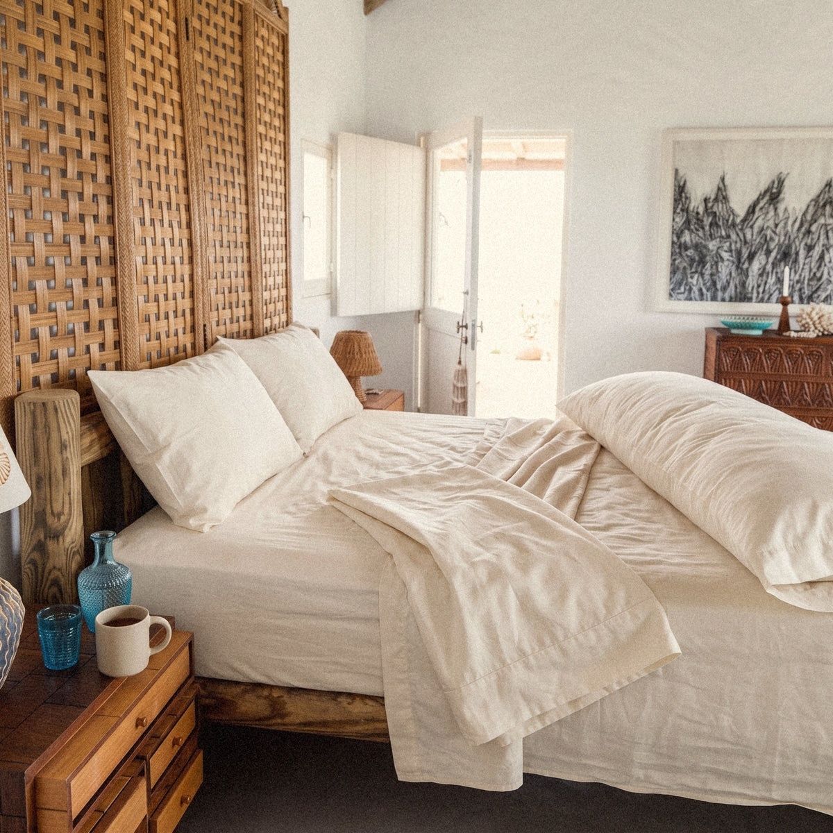 A folded organic cotton sateen body pillow case on the bed beside the body pillow.