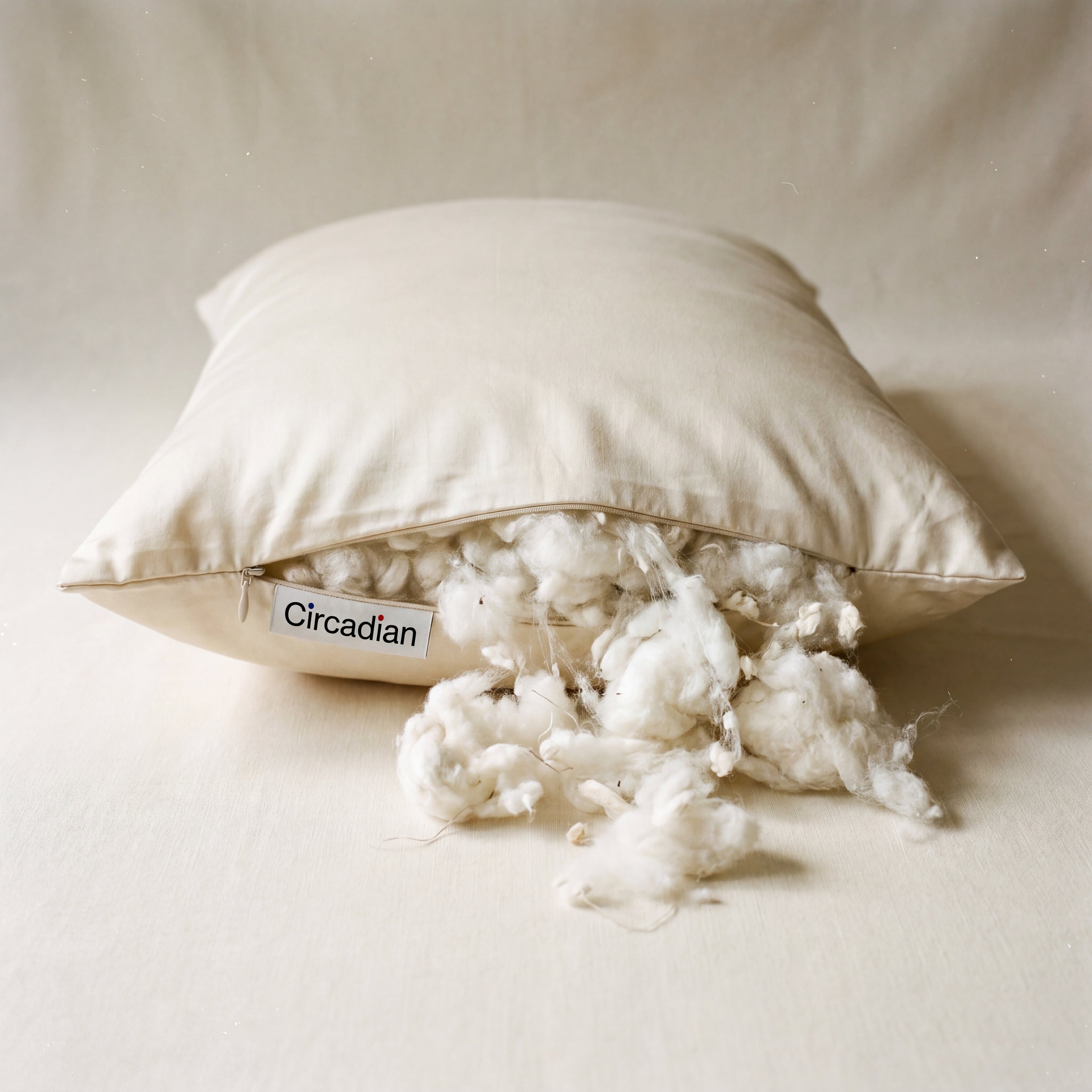 Circadian Organic Cotton Pillow with GOTS-certified cream sateen cover, side zipper open with fluffy white cotton fill spilling out