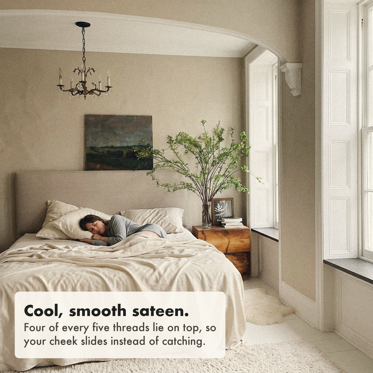A woman asleep on her side on a pillow in an organic cotton sateen pillowcase, labelled: cool, smooth sateen, four of every five threads lie on top so your cheek slides instead of catching.