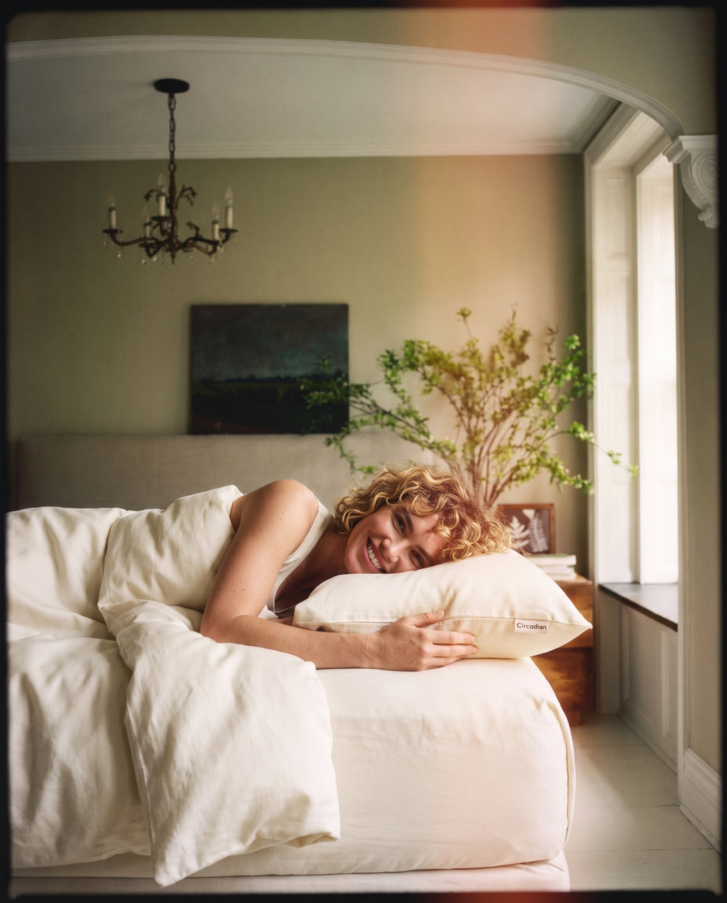 A woman resting her head on an organic cotton pillowcase