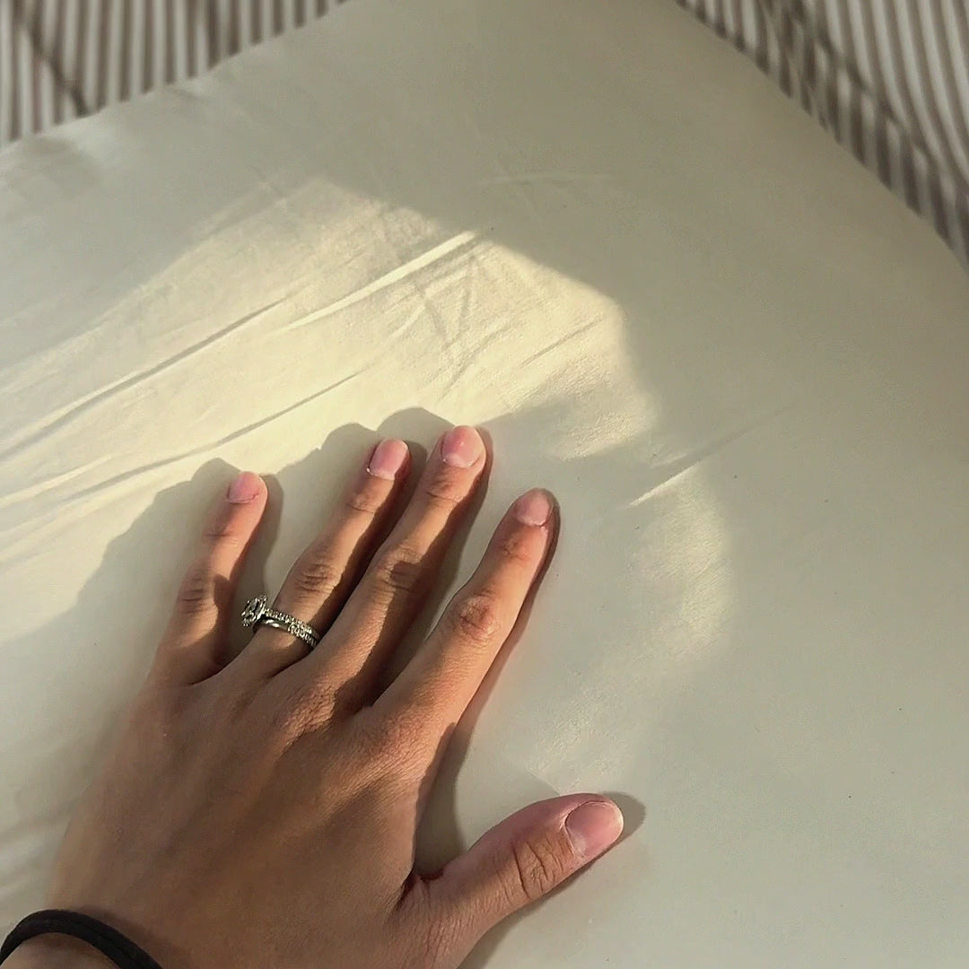 A hand presses the Organic Wool Pillow, shows the woven Circadian label, and opens the zipper to the wool inside.