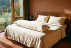 Circadian Body Pillow styled on a made bed in a warm terracotta bedroom with a canyon view.