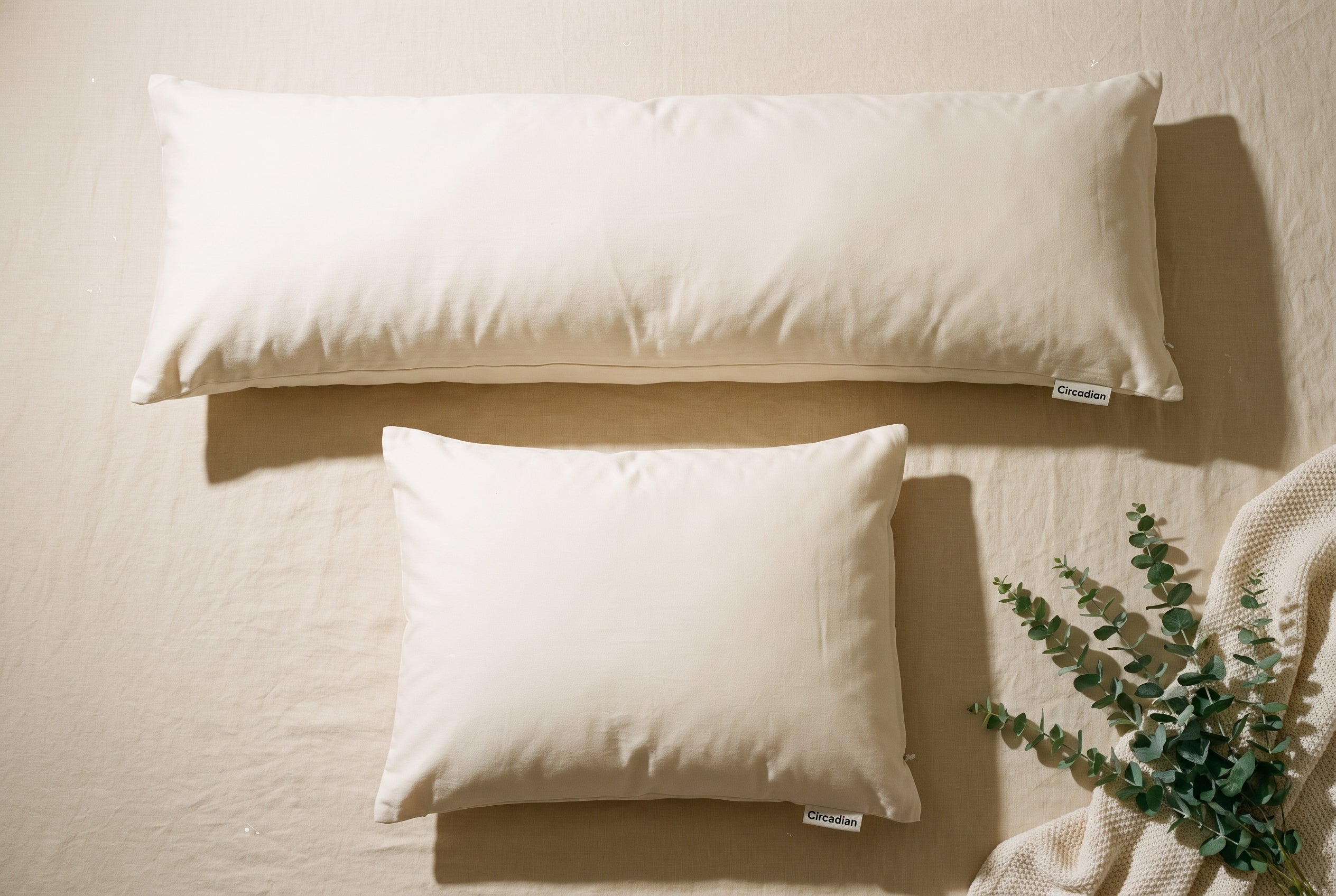 Overhead flatlay of the Circadian Body Pillow next to a standard Circadian pillow for size comparison.