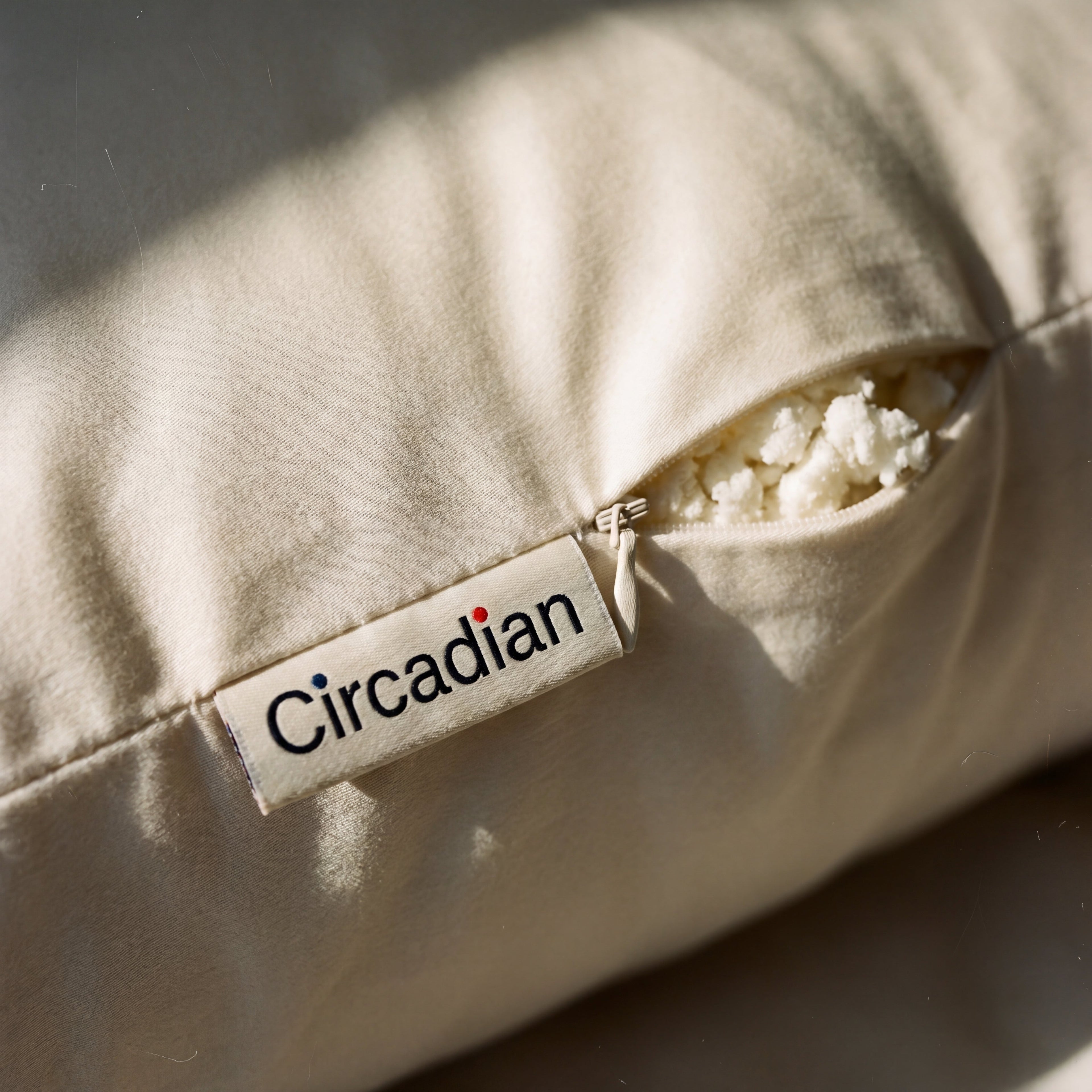Concealed zipper and woven Circadian tag detail on the Tree-Tapped Latex Pillow's organic cotton sateen cover