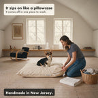 A woman pulls the waterproof cover onto the dog bed like a pillowcase while a corgi sits on it.