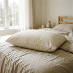 Waterproof organic cotton pillow protector zipped around a standard pillow on linen bedding, GOTS-certified cotton