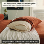 A rust pillowcase pulled back from a pillow in the waterproof organic cotton protector, its zipper open at the short end, labelled: your pillow stays clean and dry for years, sweat and spills stop at a thin film inside the cotton.
