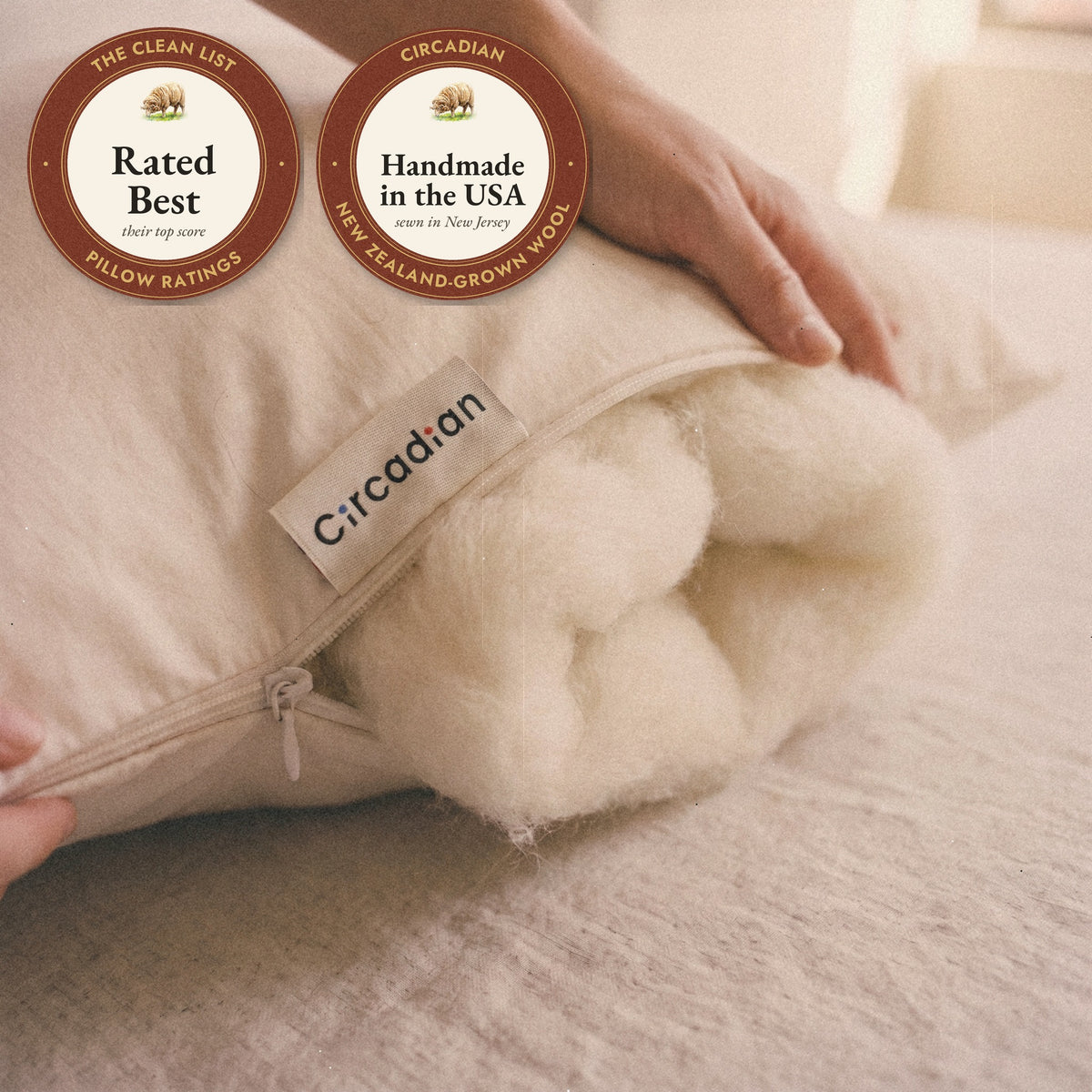 Close-up of the woven Circadian label beside the zipper of the Organic Wool Pillow with soft wool at the opening, and two seals: rated Best by The Clean List, and handmade in the USA from New Zealand-grown wool.